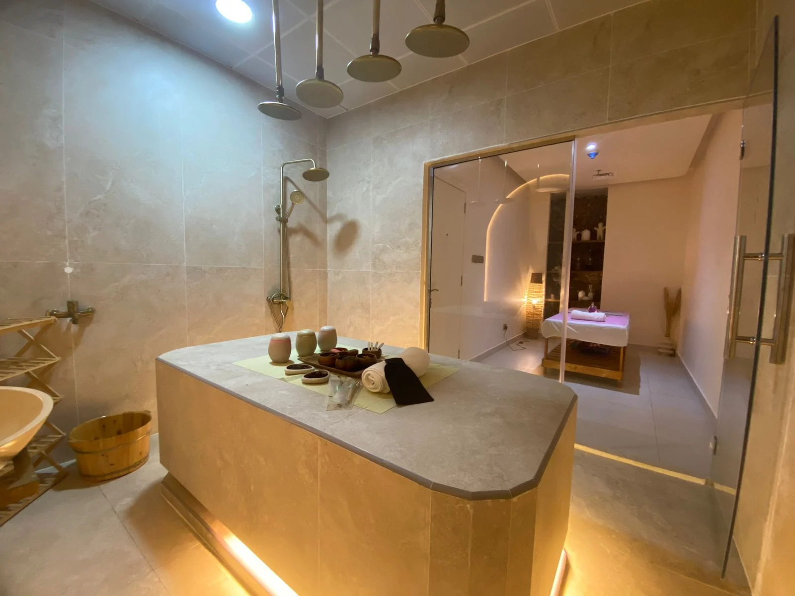 Silencio stone spa room with warm lighting and a treatment room beyond