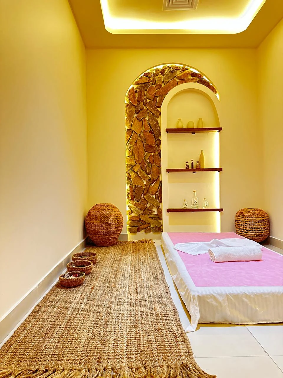 Silencio spa room with a stone arch and woven textures